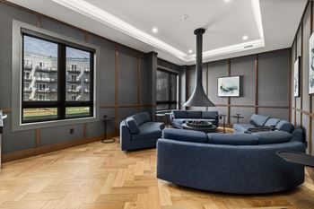 A modern living room with a blue sofa and a large window.